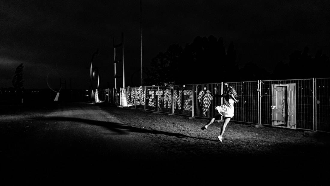 Black and white photo of a dancer in front of the closed boarder between Germany and Switzerland during the Covid Lockdown